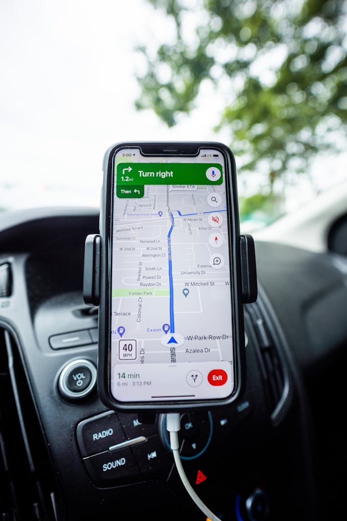services-02 Close-up of a smartphone with GPS navigation app mounted on car dashboard.